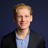 Harry Godfrey university admissions tutor and founder of The Degree Gap, member of The Tutor Collective, professional headshot smiling in suit jacket and blue shirt.