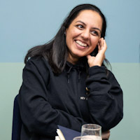 Reshmi Patel music teacher and founder of Key Sounds UK NW London, member of The Tutor Collective, professional headshot smiling in black top.